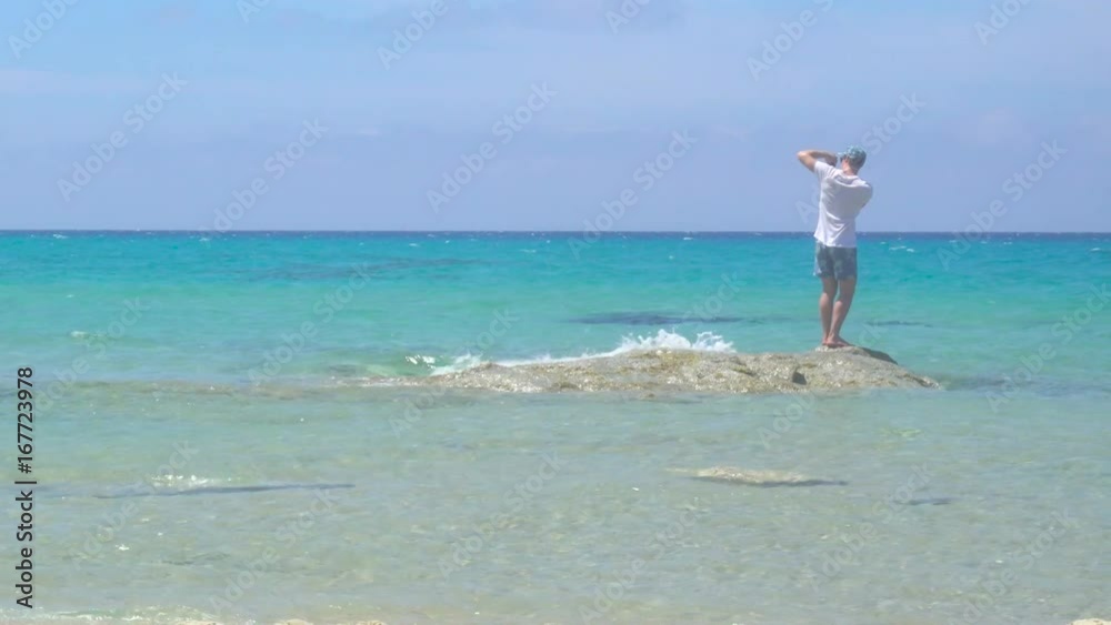 Man Taking Pictures with Smartphone on a White Wild Mediterranean Sea Beach in Italy Man Taking Pictures with Smartphone on a White Wild Mediterranean Sea Beach in Italy