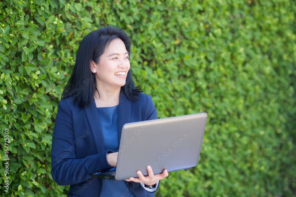 Asian businesswoman working with computer notebook in the outdoors. Asian businesswoman working with computer notebook in the outdoors.
