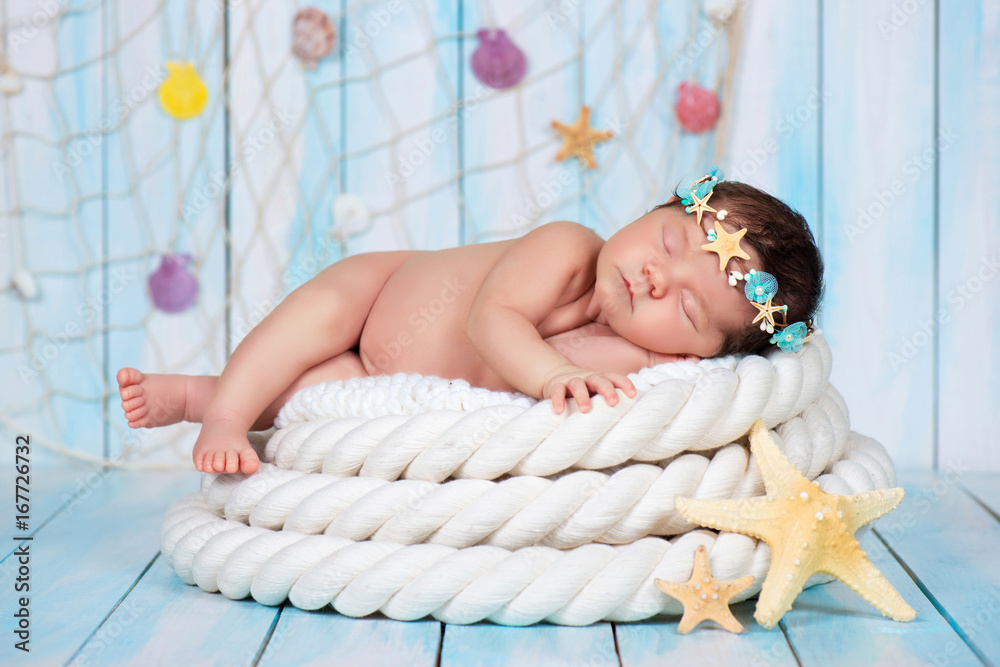 Fotografija Close portrait of a sleeping newborn girl in the maritime hoop of starfish and p