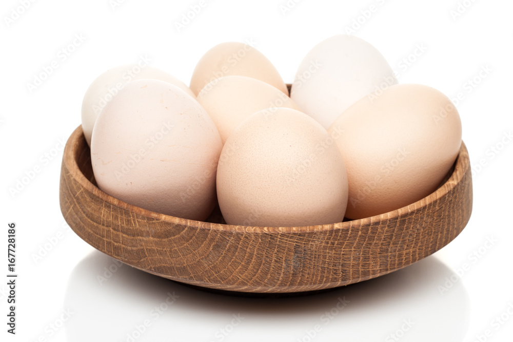 chicken eggs in a wooden plate isolated on white background