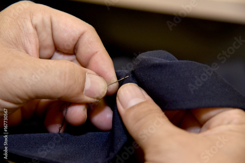Closeup hands of Tailor man working in his cloth fabric in shop, Tailoring, close up.