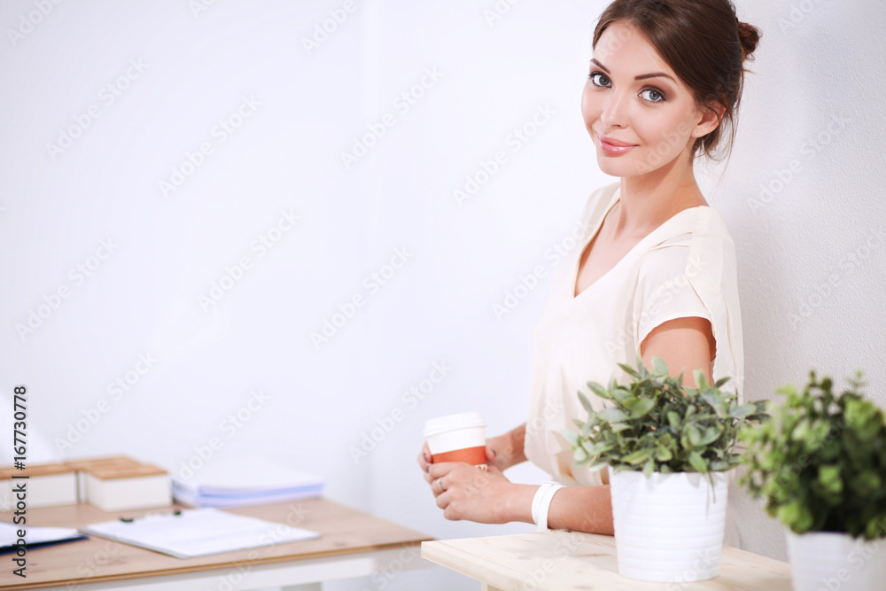 Attractive businesswoman standing near wall in office Attractive businesswoman standing near wall in office