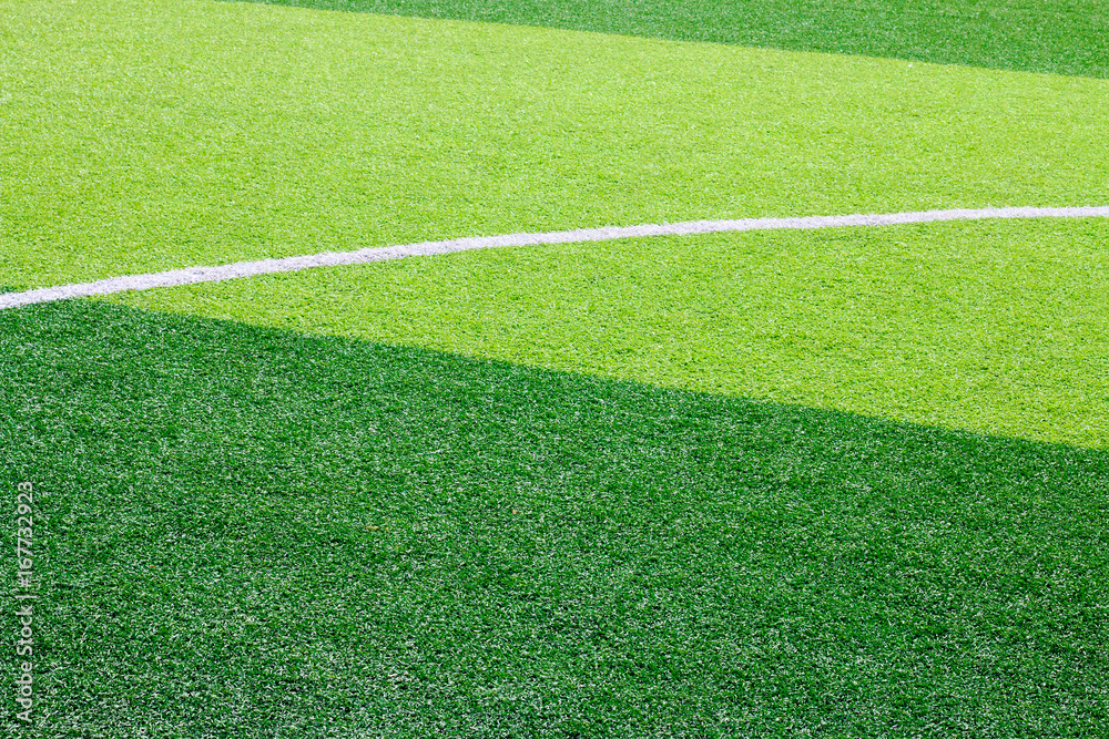Obraz premium Photo of a green synthetic grass sports field with white line shot from above