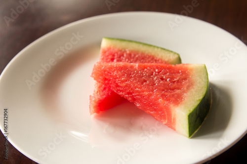 Slice of delicious watermelon on white plate background