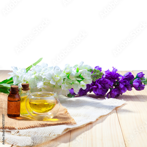 bottle of aroma essential oil or spa and natural fragrance oil with flower on wooden table isolated white background with clipping path