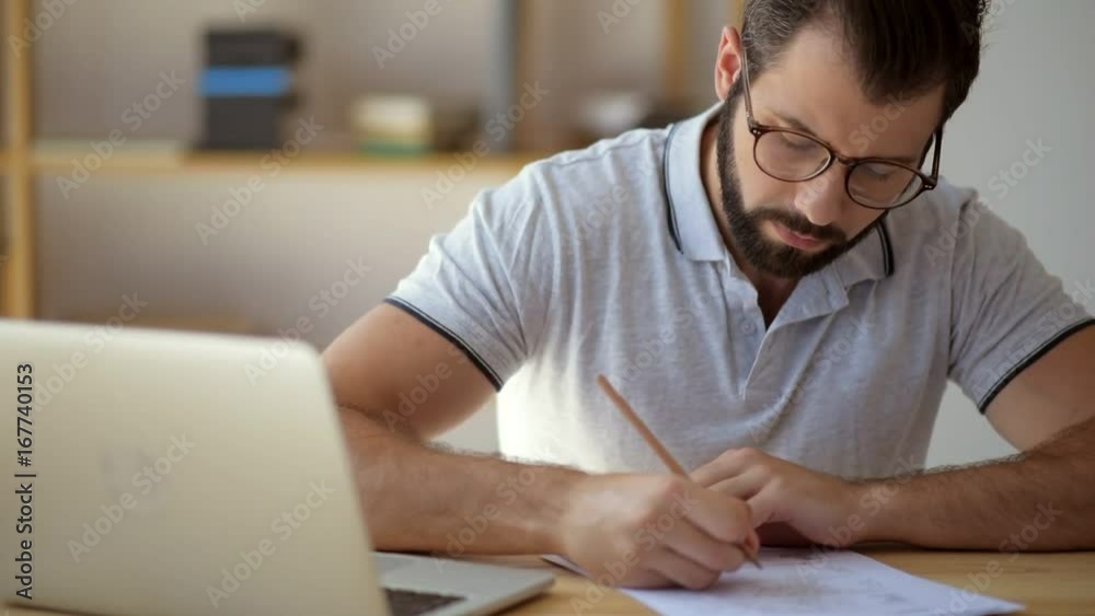 Serious student in glasses studying online from home