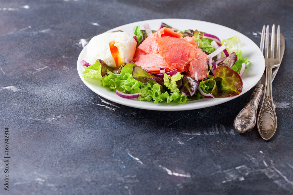 Healthy food - vegetables and salmon salad on a dark background. Selective focus. Copy space Healthy food - vegetables and salmon salad on a dark background. Selective focus. Copy space