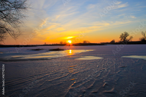 Sunset over a frozen river Dnieper on winter © olyasolodenko