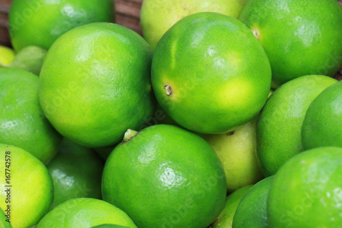 group of Fresh organic green lime Citrus lemon in wooden tray, at fresh market on asian fruit section