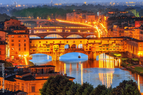 Ponte Vecchio is a bridge in Florence, located at the narrowest point of the Arno River, almost opposite the Uffizi Gallery. Night time.