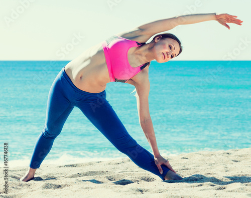 Positive female stretching muscles on the sand