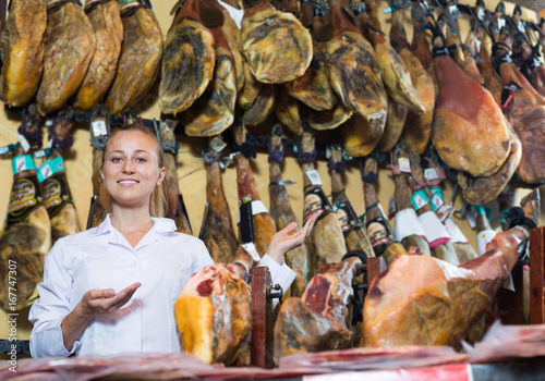 Young woman standing in meat shop with iberian ham