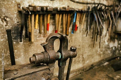 Blackmith tools in worksshop different pliers and hammers photo