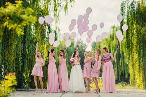 Bride with bridesmaids in pink dresses for a walk photo