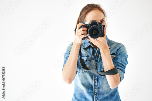 Portrait of a girl photographer on a white background