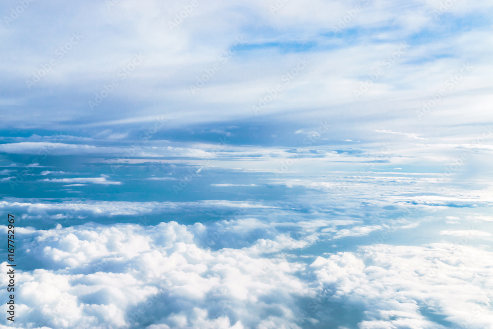over the blue clouds. View from the window of an airplane flying in the clouds over the blue clouds. View from the window of an airplane flying in the clouds