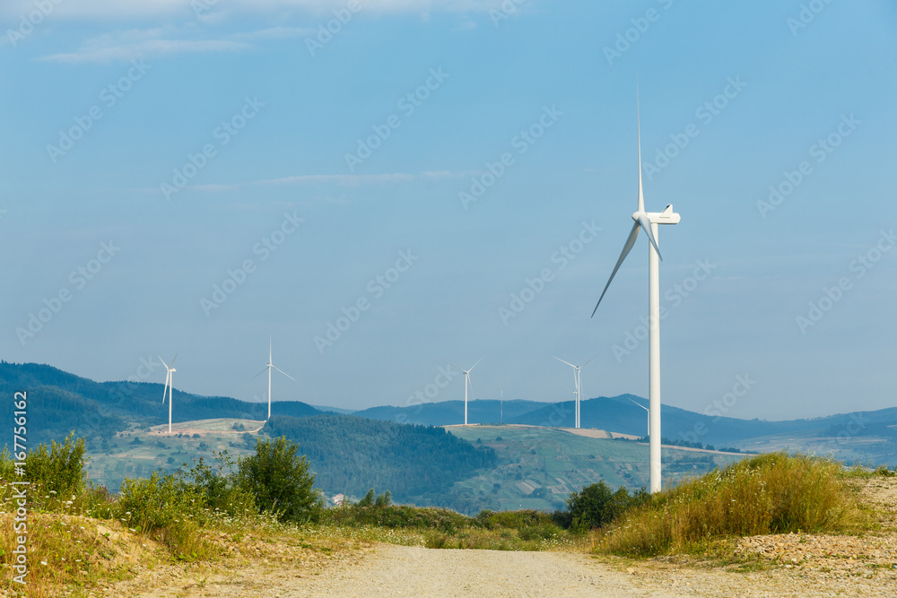 Wind turbines standing on a heels among fields