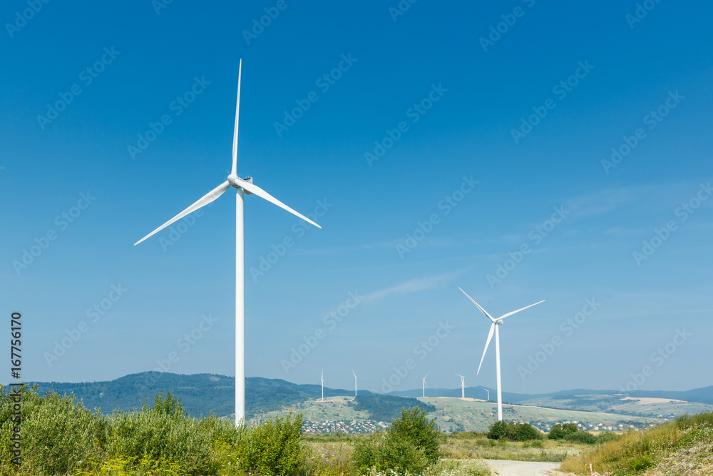Wind turbines standing on a heels among fields Wind turbines standing on a heels among fields