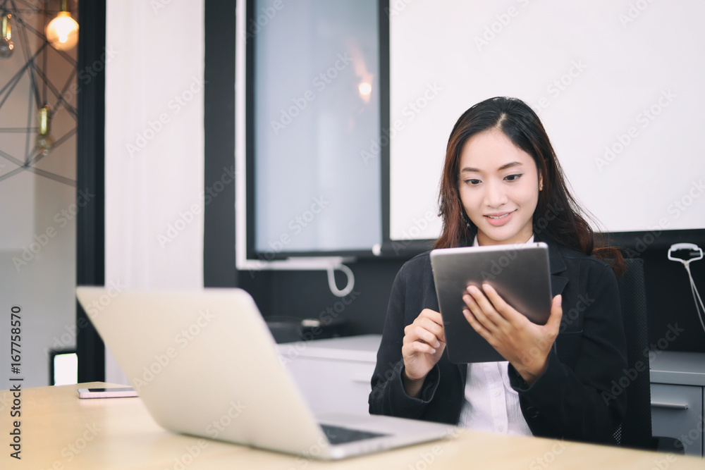 Asian business women using tablet for working at office relax time Asian business women using tablet for working at office relax time