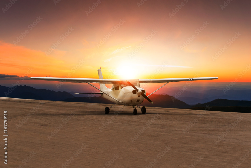 Naklejka premium old propeller plane taxi on airport runway against beautiful sun set sky