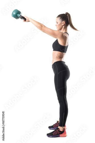 Side view of fitness gym woman doing kettlebell swing training in high position. Full body length portrait isolated on white studio background