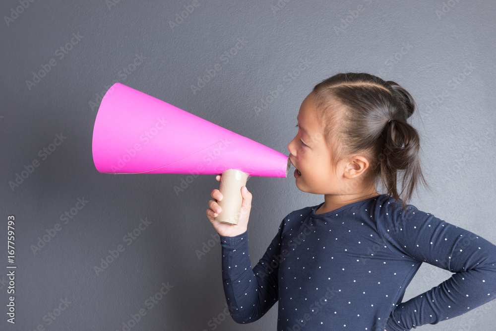 Kid shouting through pink paper megaphone. Kid shouting through pink paper megaphone.