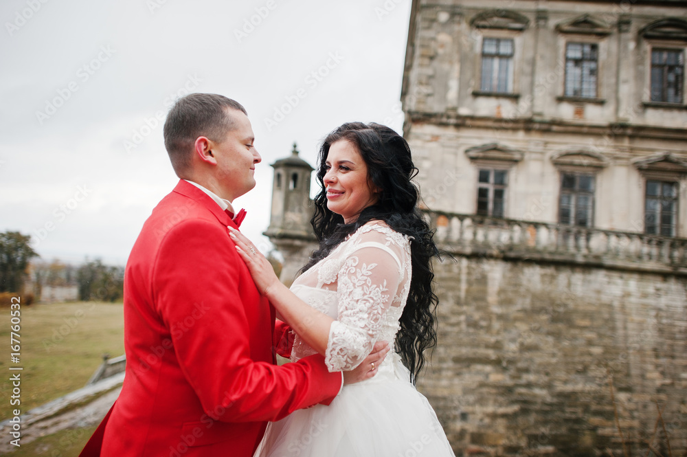 Beautiful wedding couple standing outside with a beautiful architectural background.