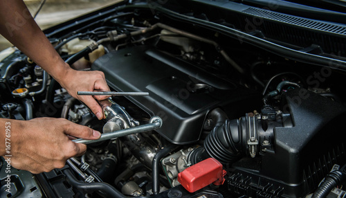 Hand of mechanic is repairing car engine