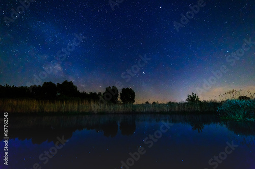 Starry sky and milky way over the water.