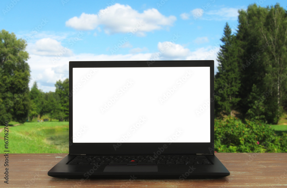 Image of outdoors with open laptop and empty white screen for copy space Image of outdoors with open laptop and empty white screen for copy space