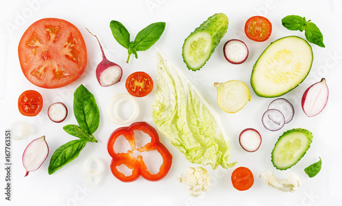 Colorful set of vegetables of red and green color isolated on white background top view, design for vegetable menu. Tomato onion cucumber sweet pepper zucchini Peking cabbage cauliflower radish basil.