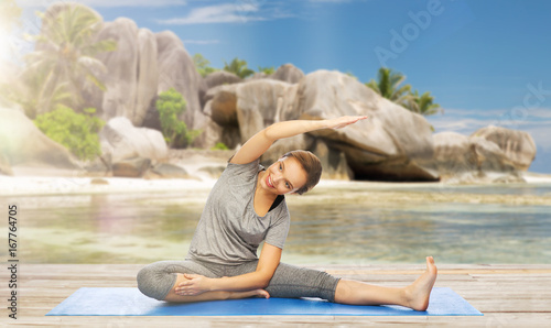 happy woman doing yoga and stretching on beach