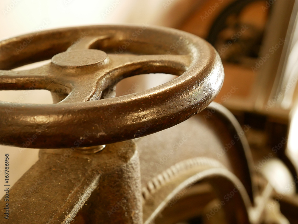 Old press, detail for tightening screw. Toned style photo. Old press, detail for tightening screw. Toned style photo.