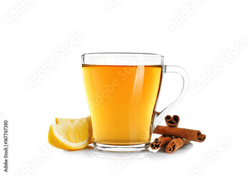 Cup of aromatic hot tea with cinnamon and lemon on white background