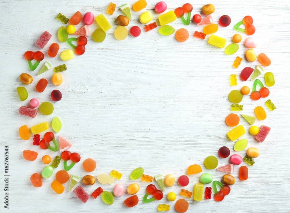 Frame made of different candies on wooden background Frame made of different candies on wooden background