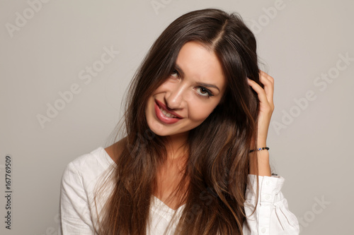 seductive and smiling young woman on a gray background © vladimirfloyd