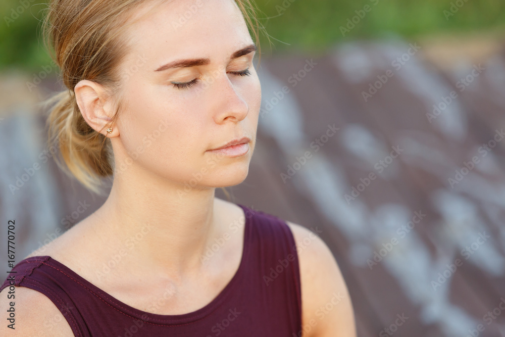 Close-up of young woman meditates while practicing yoga outdoors. Freedom, Calmness and relax, woman happiness concept. Close-up of young woman meditates while practicing yoga outdoors. Freedom, Calmness and relax, woman happiness concept.