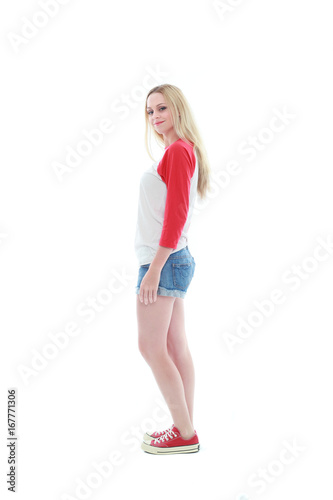 full length portrait of a blonde girl wearing casual t-shirt and denim shorts. isolated on white background.