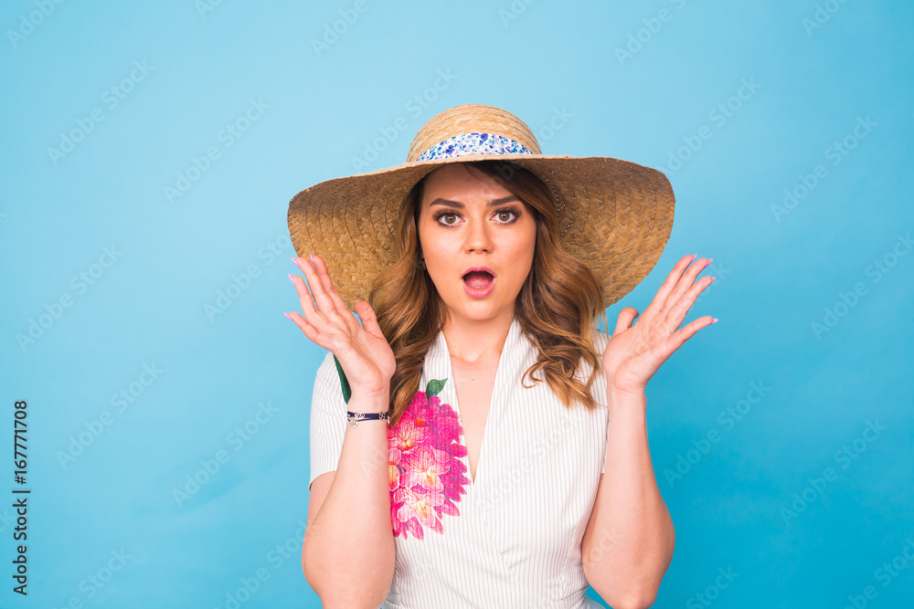 Beautiful excited surprised young woman over blue background with copy space.