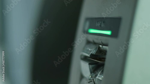 Close up shot of man hands putting the credit card to the ATM in the airport. photo