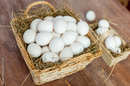 Chicken eggs in basket on wooden background