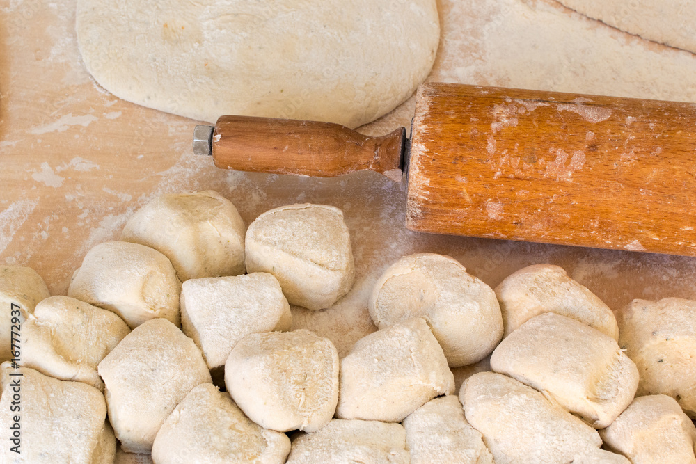Fresh pizza dough with a rolling pin on a wooden table. Fresh pizza dough with a rolling pin on a wooden table.