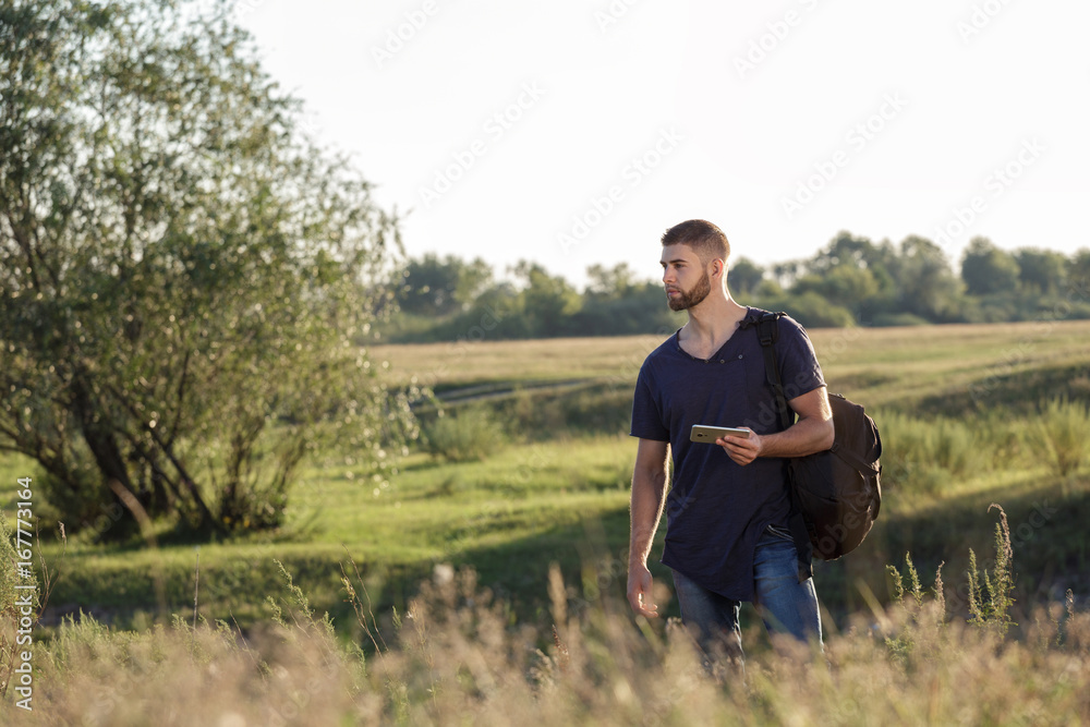 Young man on hike in nature using phone Young man on hike in nature using phone