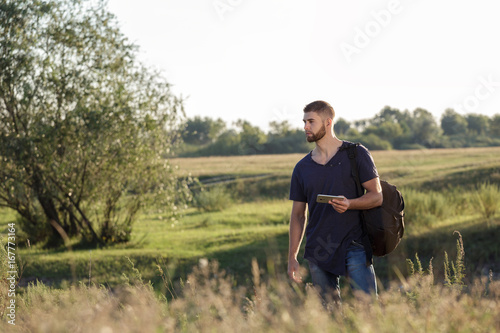 Young man on hike in nature using phone