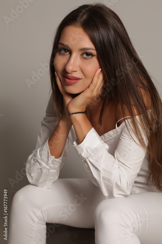 seductive and smiling young woman on a gray background
