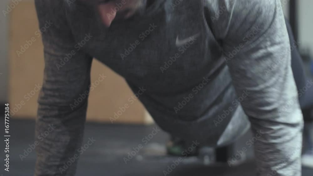 Fit Male Personal Trainer doing push ups in Gym Fit Male Personal Trainer doing push ups in Gym