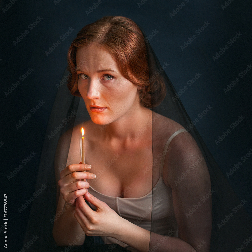 Obraz premium Woman with candle under veil. Halloween photo