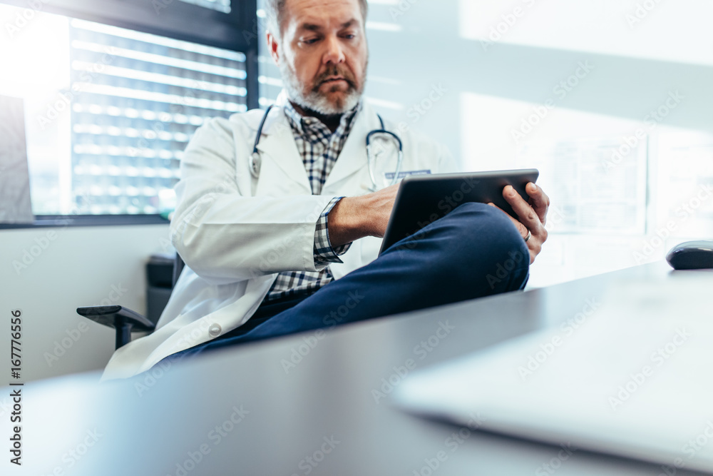 Medical practitioner using tablet pc in his clinic Medical practitioner using tablet pc in his clinic