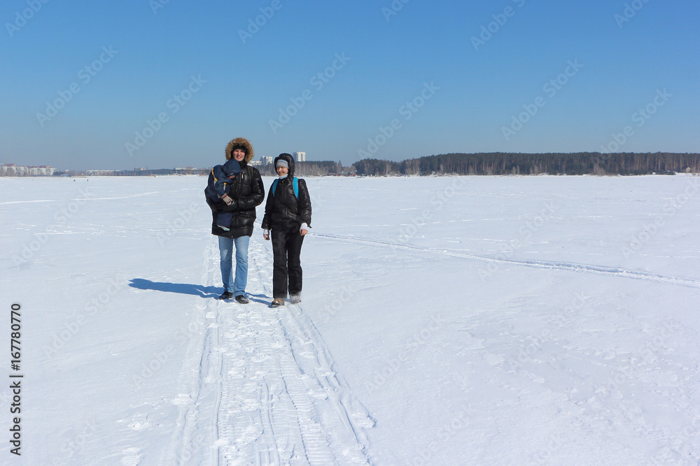 Man, woman and the child walking on the snow river in the winter, Siberia, Russia