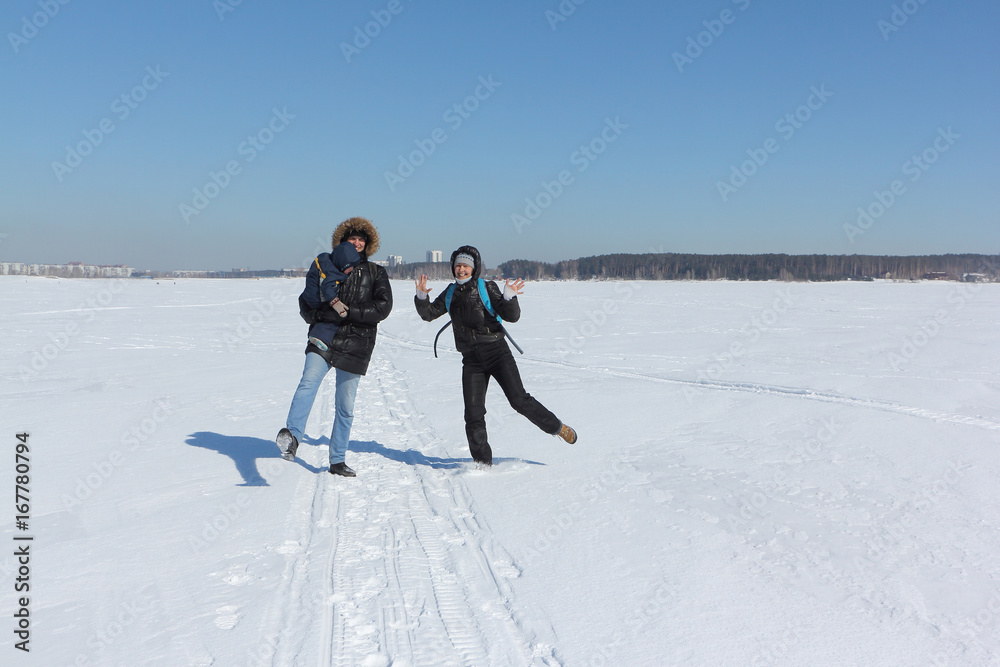 Man, woman and the child walking on the snow river in the winter, Siberia, Russia